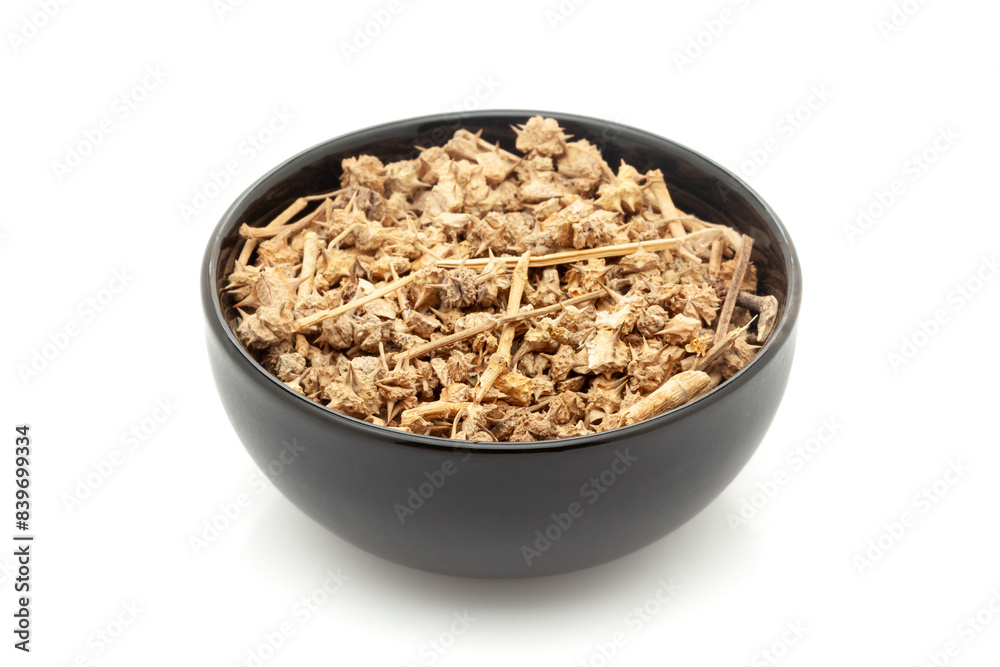 Close-up of Dry Organic Organic Gokhuru (Tribulus Terrestris) fruits, in black ceramic bowl. Isolated on a white background. Close-up of Dry Organic Organic Gokhuru (Tribulus Terrestris) fruits, in black ceramic bowl. Isolated on a white background.