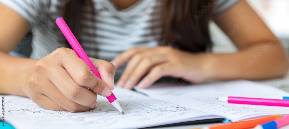 Concentrated woman writing on notepad while actively involved in work and academic study Concentrated woman writing on notepad while actively involved in work and academic study
