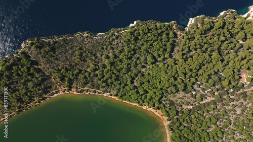 Drone view directly from above on coniferous forest between waters of sea and salt lake in Dugi Otok island, Telascica National Park, Croatia photo