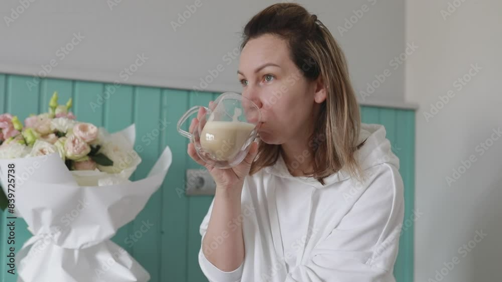 Serene Morning Routine of a Woman Enjoying Hot Beverage and Flowers Indoors Serene Morning Routine of a Woman Enjoying Hot Beverage and Flowers Indoors