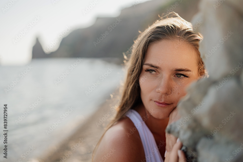 A woman with long hair is looking out at the ocean A woman with long hair is looking out at the ocean