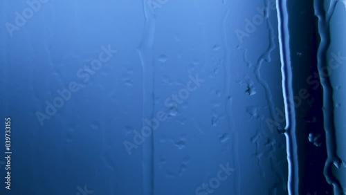 Water drops flowing on window glasses surface. Natural Pattern of raindrops on clear window.
