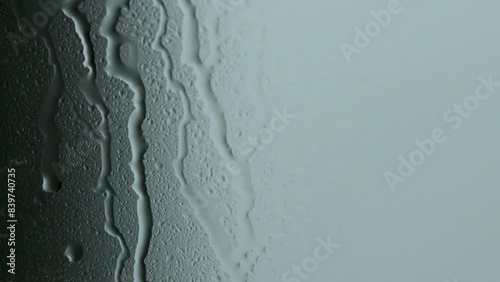 Water drops flowing on window glasses surface. Natural Pattern of raindrops on clear window.