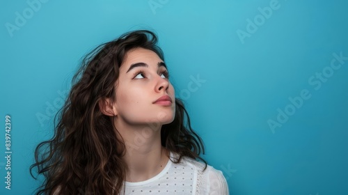 femme pensive regardant vers le haut espace libre pour texte fond bleu pastel portrait photographie