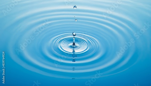 Close-up of a falling drop of water creating circular waves on the calm surface of the water. The concept of purity, tranquility and harmony of nature