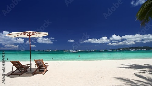Sun umbrellas and beach chairs on tropical beach with palm trees. Summer vacation. Boracay photo