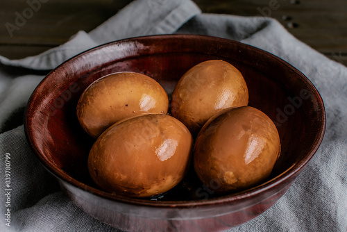 Close-up View of Soy Sauce Eggs in a Wooden Bowl: Soft-boiled eggs that have marinated in a spiced soy sauce marinade photo