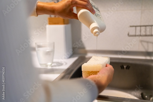 Bilde på lerret Happy Asian woman do housework washing dishes in the sink after dinner in the kitchen at apartment
