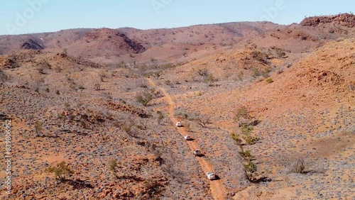 Four-wheel drive vehicles struggle through a dusty track in the Australian outback. The Flinders Ranges are arid and rugged with beautiful colours. Perfect for adventure, travel, or camping. photo