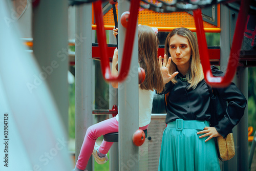 Mother Saying Stop to her Daughter at the Playground. Unhappy mom scolding her daughter being overcautious 

