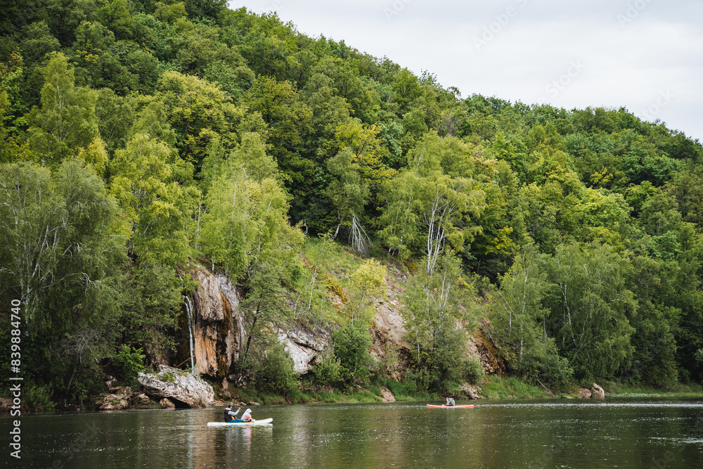 Immersed in natures beauty, a peaceful kayaking experience unfolds on a tranquil lake, connecting person with serene surroundings, embodying calmness amidst trees and natural landscapes