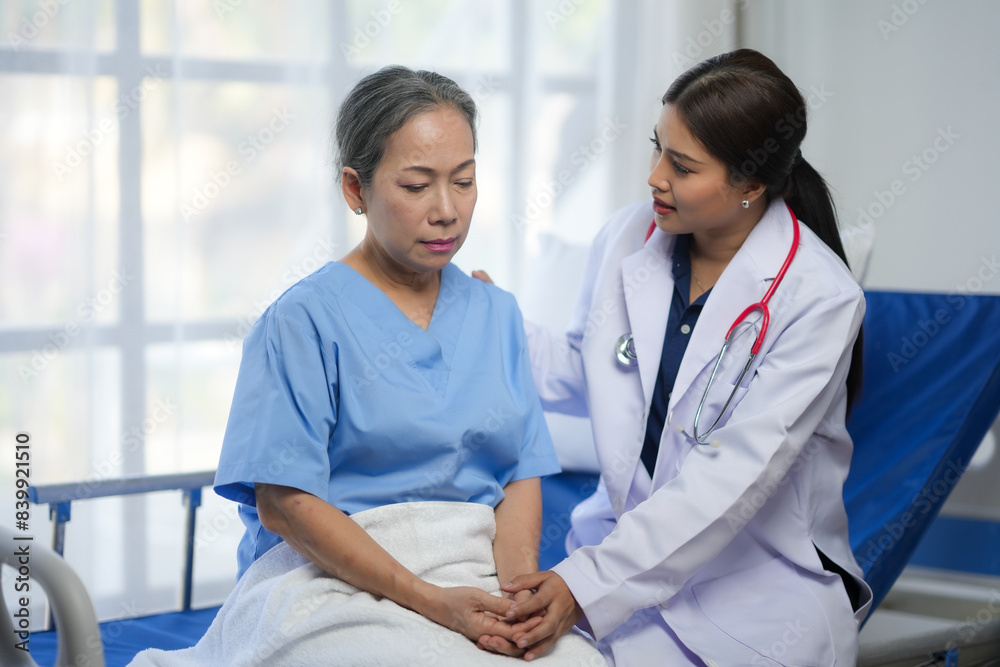 A compassionate doctor provides support and care to her elderly patient in a hospital room setting, fostering trust and communication. A compassionate doctor provides support and care to her elderly patient in a hospital room setting, fostering trust and communication.