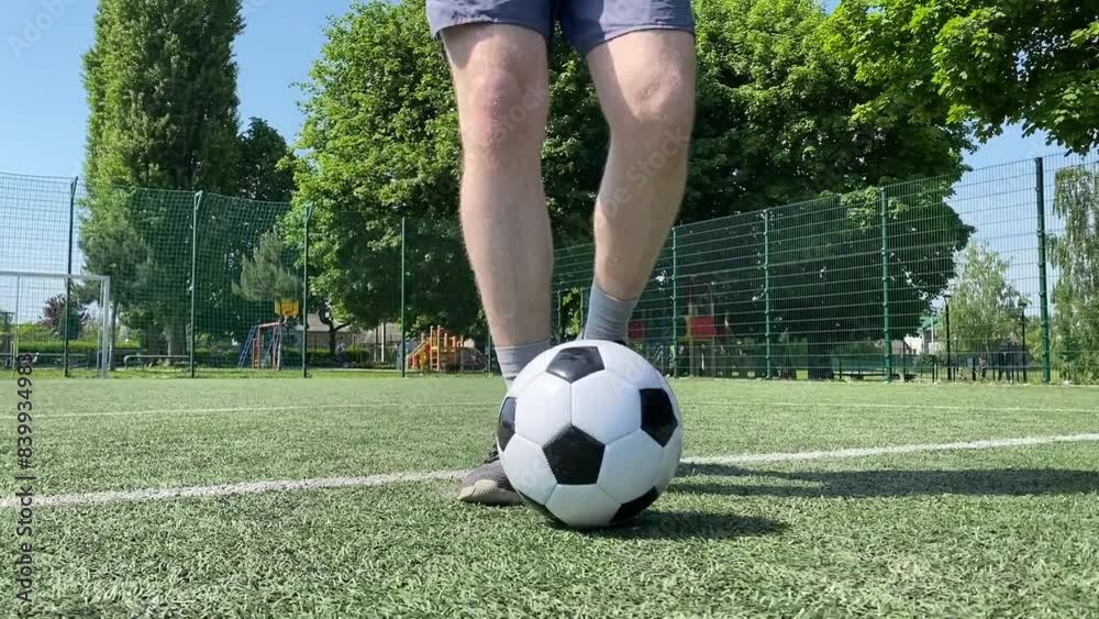 A young man in sportswear is playing soccer, training on a football pitch in the morning. Dedication and passion for the sport, the essence of morning exercise and practice outdoors A young man in sportswear is playing soccer, training on a football pitch in the morning. Dedication and passion for the sport, the essence of morning exercise and practice outdoors