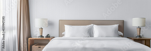Modern hotel room with elegant bedding and stylish decor. Neutral tones and use of natural light.