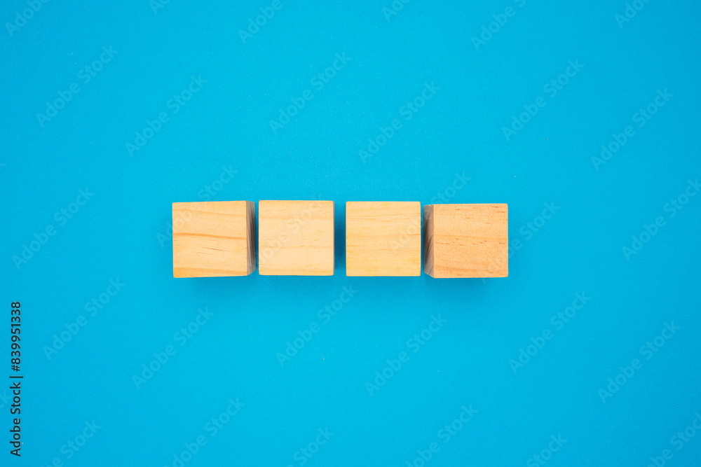 Four wooden cubes are on a blue background. Four wooden cubes are on a blue background.