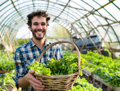Smiling Caucasian farmer man holding baskets full of vegetables salad in a greenhouse garden
