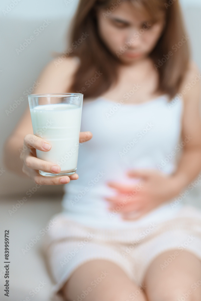 Lactose intolerance and Milk allergy concept. woman hold Milk glass and having abdominal cramps and pain when drink Cow Milk. Symptom stomach ache, Dairy intolerant, Nausea, Bloating, Gas and Diarrhea Lactose intolerance and Milk allergy concept. woman hold Milk glass and having abdominal cramps and pain when drink Cow Milk. Symptom stomach ache, Dairy intolerant, Nausea, Bloating, Gas and Diarrhea