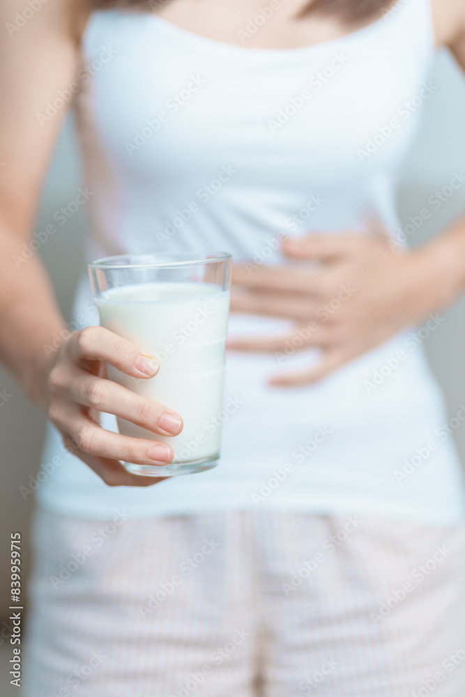 Lactose intolerance and Milk allergy concept. woman hold Milk glass and having abdominal cramps and pain when drink Cow Milk. Symptom stomach ache, Dairy intolerant, Nausea, Bloating, Gas and Diarrhea Lactose intolerance and Milk allergy concept. woman hold Milk glass and having abdominal cramps and pain when drink Cow Milk. Symptom stomach ache, Dairy intolerant, Nausea, Bloating, Gas and Diarrhea