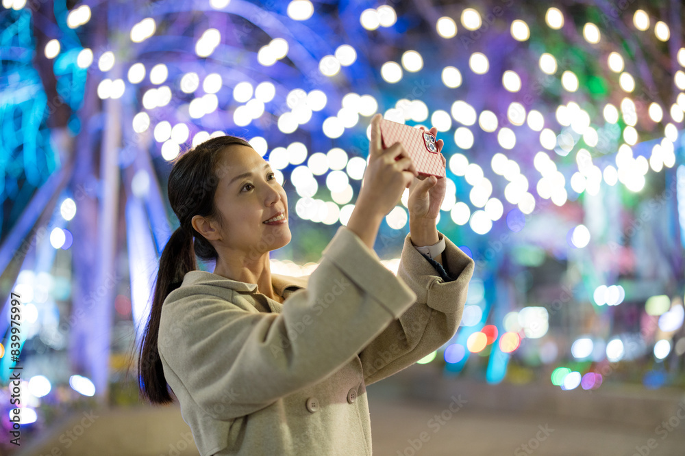 Naklejka premium Tourist woman visit taipei city and use mobile phone to take photo at night