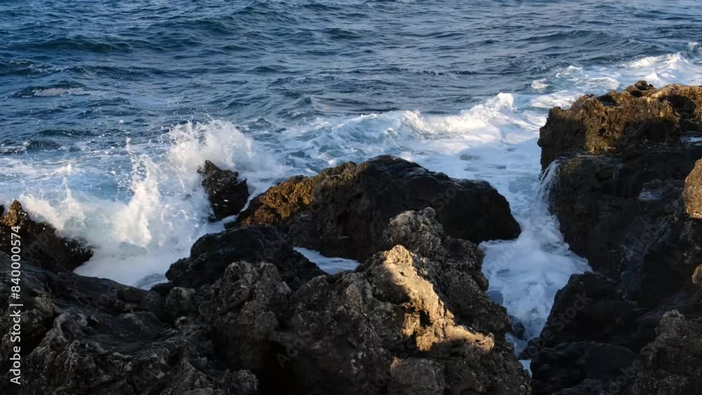 Ocean waves rocks slow motion. Huge foaming waves roll on the stone shore. Dark blue turquoise sea water. The concept of the elements, windy weather, tropical climate. Fascinating movement of water. Ocean waves rocks slow motion. Huge foaming waves roll on the stone shore. Dark blue turquoise sea water. The concept of the elements, windy weather, tropical climate. Fascinating movement of water.