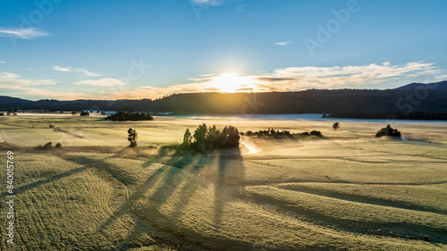 There was low fog and mist hovering above the frosty farm fields at sunrise