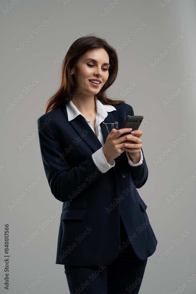 Businesswoman in a blazer with black hair gesturing with phone in hand Businesswoman in a blazer with black hair gesturing with phone in hand