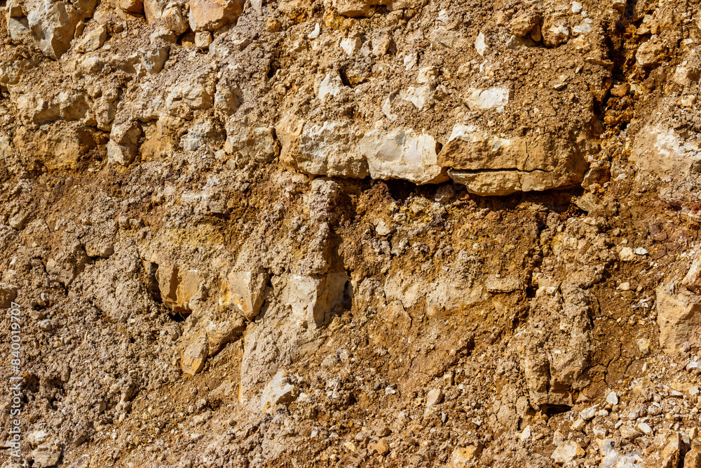 View of a wall at a stone quarry with limestone and crumbling dried clay. Lower Carboniferous, Russia View of a wall at a stone quarry with limestone and crumbling dried clay. Lower Carboniferous, Russia