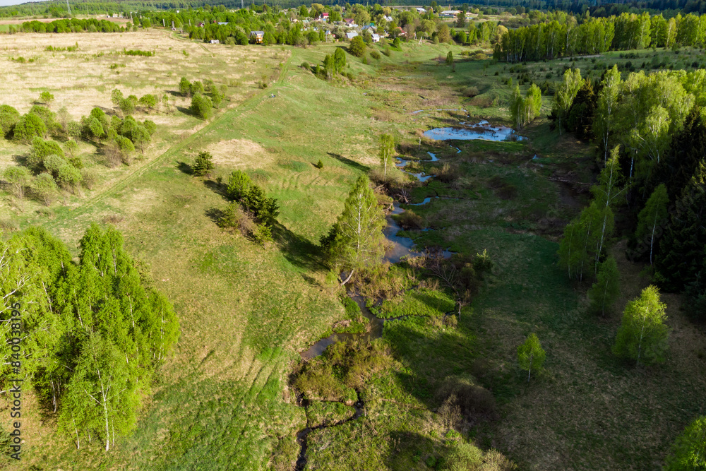 A picturesque aerial view of a stream flowing through a green valley. Neighborhood of the village of Krivonosovo, Maloyaroslavetsky district A picturesque aerial view of a stream flowing through a green valley. Neighborhood of the village of Krivonosovo, Maloyaroslavetsky district