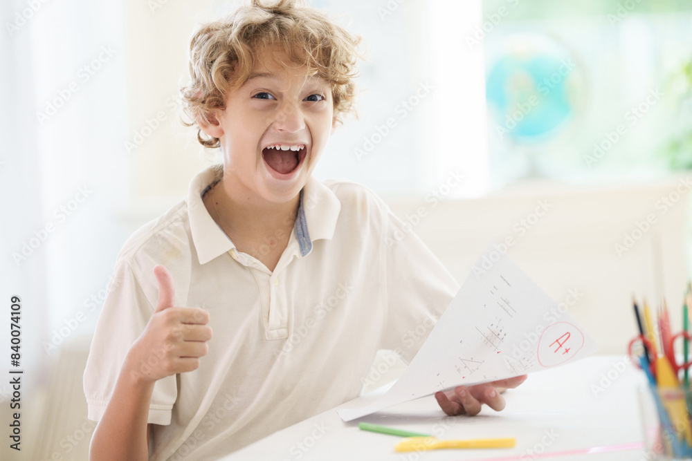 Child holding school test with excellent A grade.