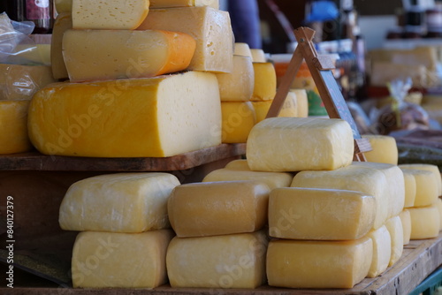 Big blocks of Cheese stacked on a table in a market. photo