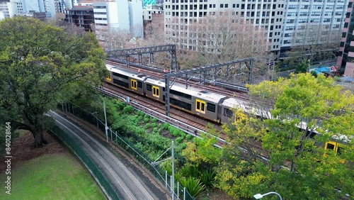 Landscape view of commuter train moving along railway tracks with buildings pathway Central Station Surry Hills Australia travel transport interchange photo