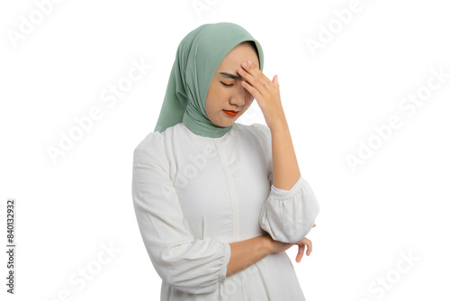 Stressed young Asian woman in green hijab and white blouse touching her forehead in frustration isolated on white background