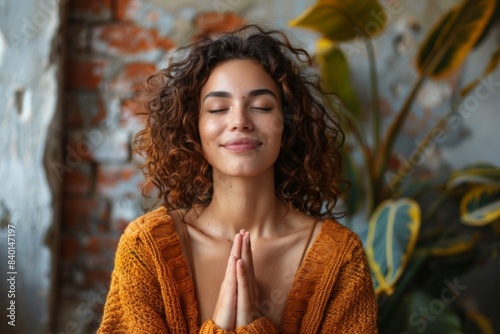 Woman in mustard sweater meditating yoga pose photo