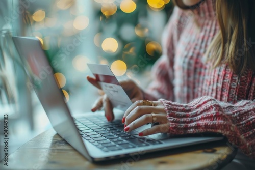 Person using laptop with credit card photo