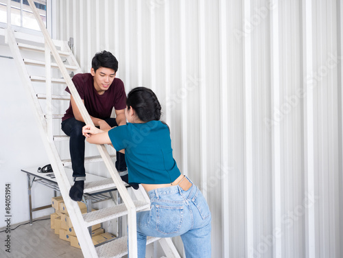 Asian young couple chatting on a white staircase in a modern minimalist room showing a moment of connection and interaction while relaxation after moving boxes