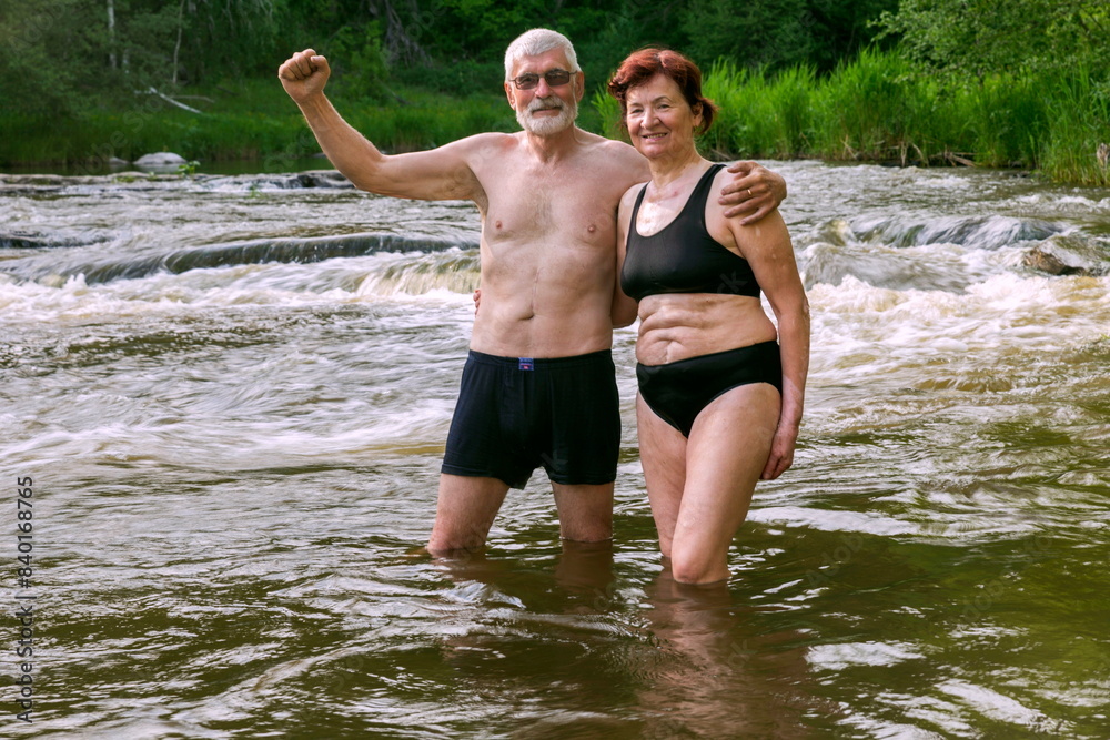 Fototapeta premium sports elderly couple bathes in the mountain river Sakmara in the Southern Urals