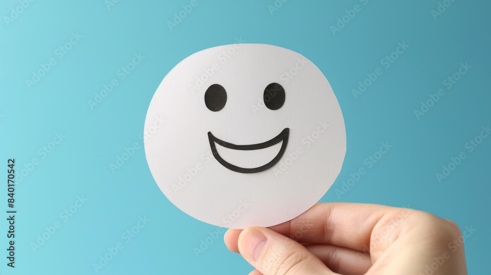 Celebrate World Mental Health Day with positive thinking. Hand holding paper cut smile face for mental health assessment. Celebrate World Mental Health Day with positive thinking. Hand holding paper cut smile face for mental health assessment.