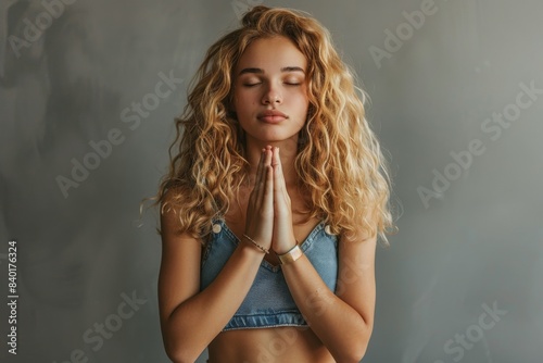 Woman in blue bikini and bracelet praying