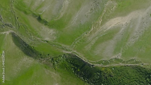 directly above aerial view of grassy green mountain hills at sunny spring day. photo