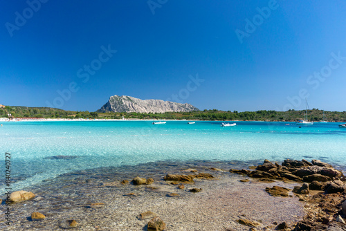 Fototapeta Naklejka Na Ścianę i Meble -  The splendid beach of Cala Brandinchi, with white sand and emerald blue sea, behind the beach a suggestive lake as well as the panorama with Tavolara in the background. San Teodoro, Sardinia, Italy