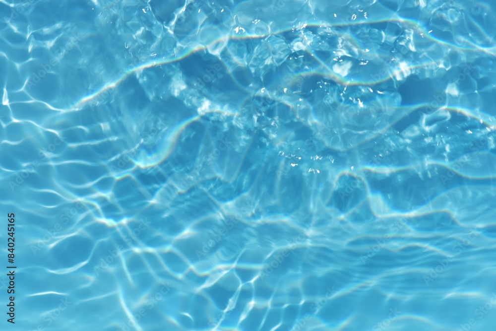 Blue water with ripples on the surface. Defocus blurred transparent blue colored clear calm water surface texture with splashes and bubbles. Water waves with shining pattern texture background. Blue water with ripples on the surface. Defocus blurred transparent blue colored clear calm water surface texture with splashes and bubbles. Water waves with shining pattern texture background.