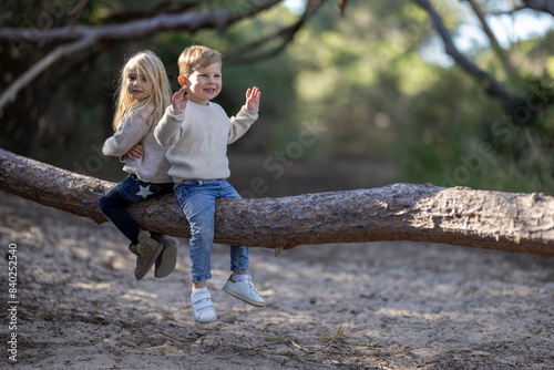 Obraz na płótnie Little boy and girl having fun sitting on a trunk w salonie