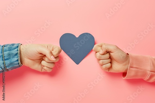 Hands hold a pink paper heart on a pink background