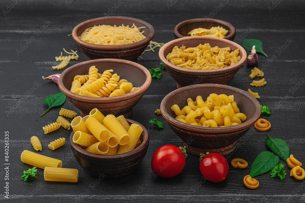 Pasta. Various kinds of uncooked pasta and noodles over wooden background. Traditional Italian