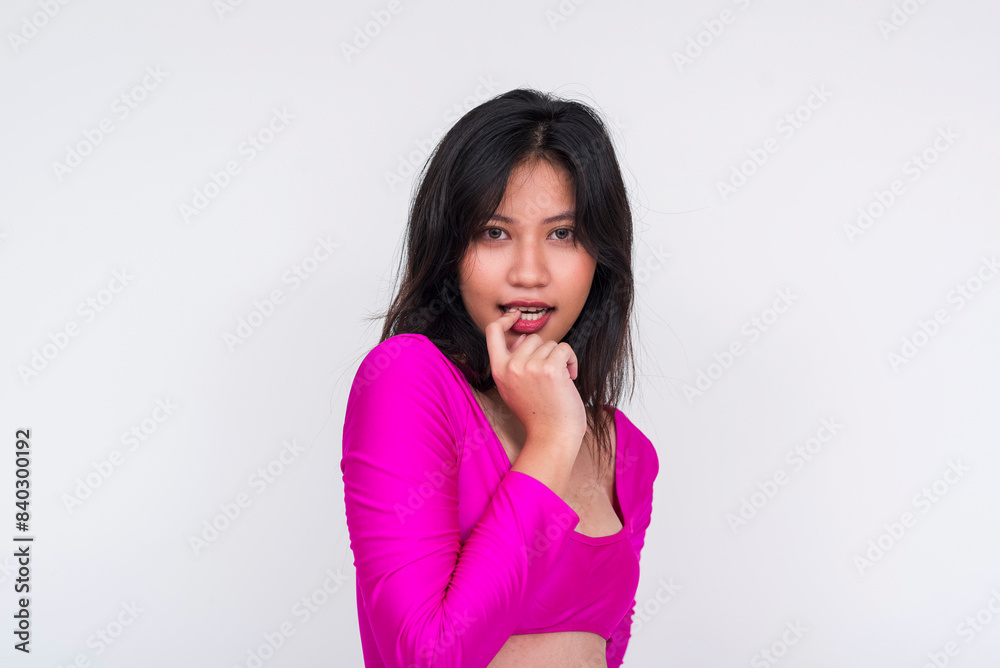 Cute young asian woman in a magenta cutout dress. Flirting with someone overtly, biting her finger. Giving in to temptation. Isolated on a white background. Cute young asian woman in a magenta cutout dress. Flirting with someone overtly, biting her finger. Giving in to temptation. Isolated on a white background.