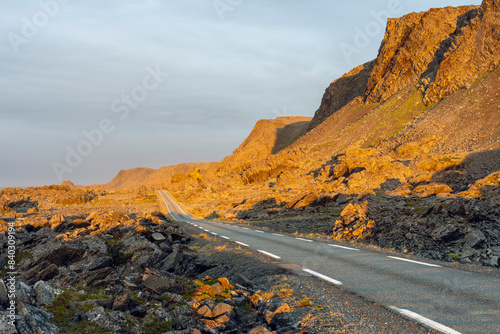 The road to Hamningberg through the rocky coastal landscape on a beautiful summer evening, Varanger Peninsula, Norway photo