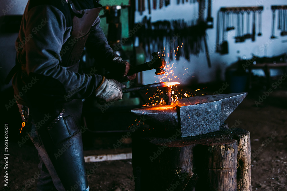 Blacksmith shaping metal on an anvil with sparks flying Blacksmith shaping metal on an anvil with sparks flying