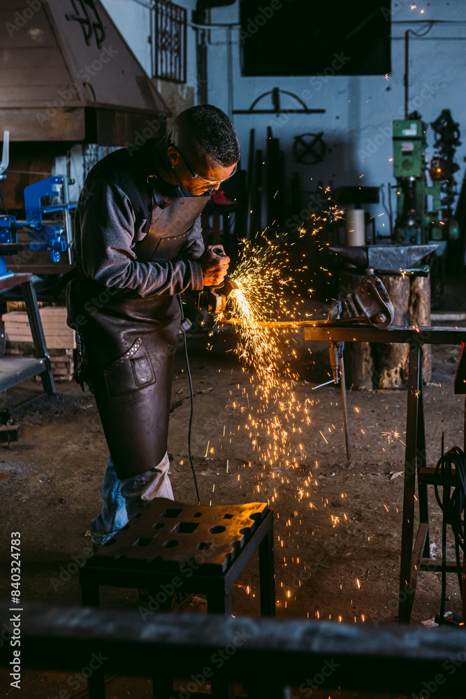 Artisan blacksmith working with metal in a workshop Artisan blacksmith working with metal in a workshop
