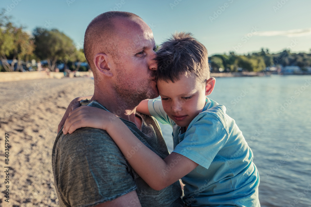 Fototapeta premium Photo of smiling boy and his dad at the beach.