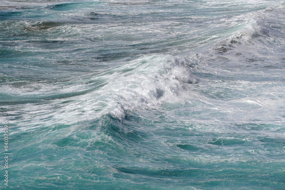 Fototapeta premium Wellenformationen mit Gischt an der Küste mit Schaumkronen